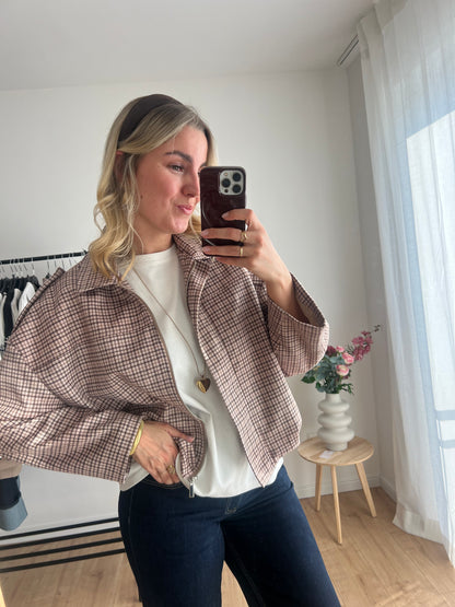 Detailaufnahme der karierten Bomberjacke mit beige-braun-hellgrünem Muster und elastischem Material, Model Bild