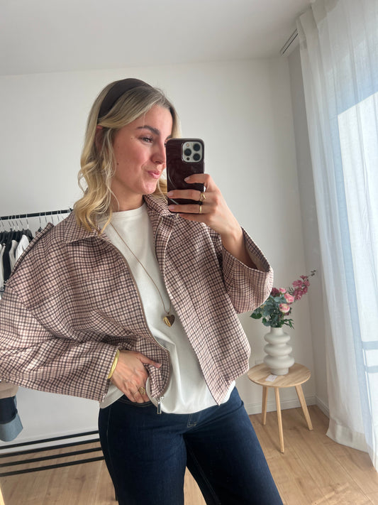 Detailaufnahme der karierten Bomberjacke mit beige-braun-hellgrünem Muster und elastischem Material, Model Bild