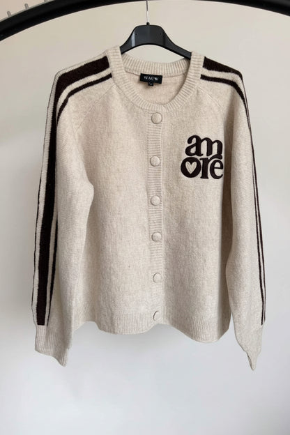 Beige Strickjacke mit braunen Details und Amore-Stickerei. 