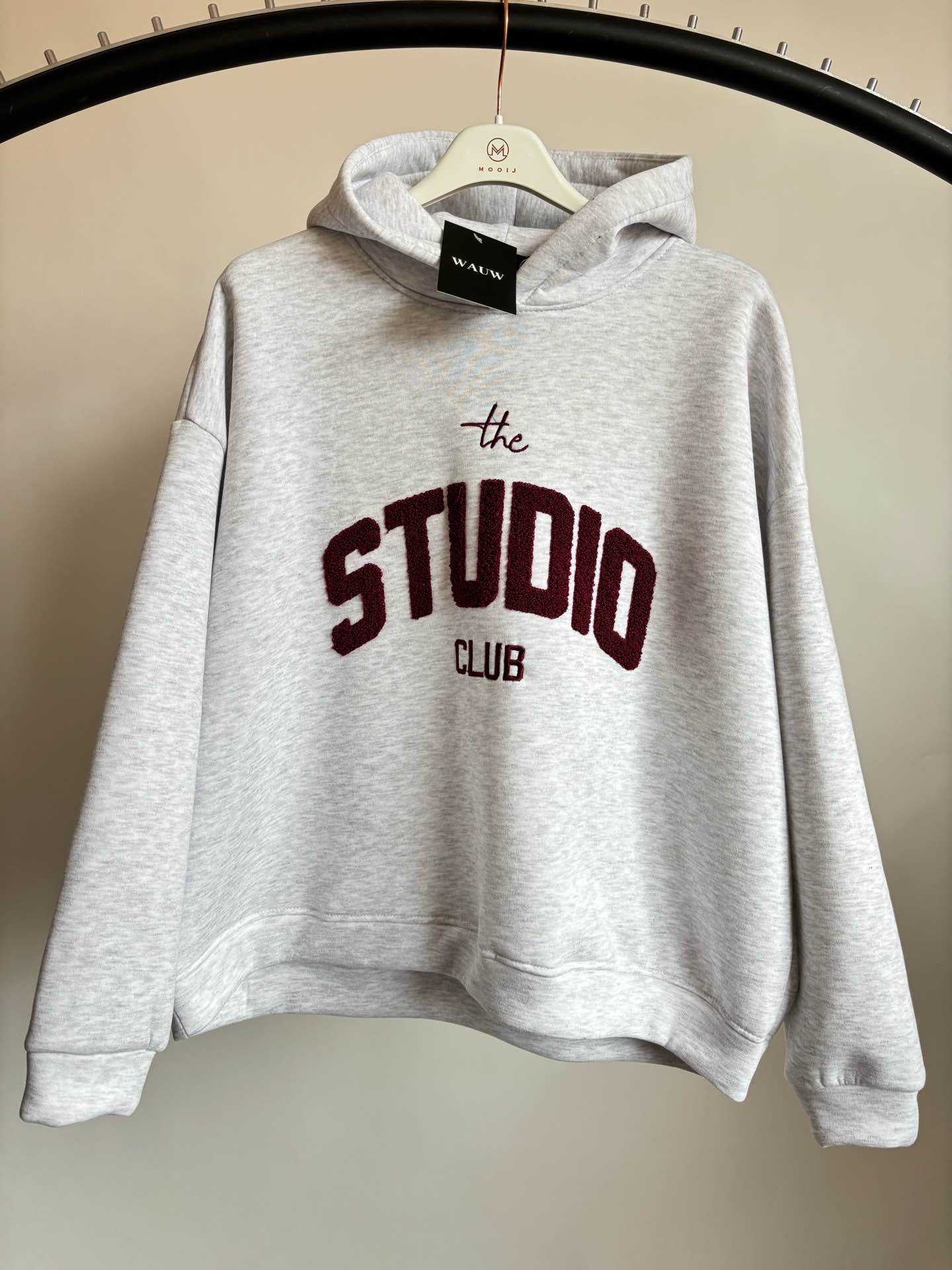 Studio Club Hoodie, Produkt Bild, Grauer Hoodie mit Bordeaux Text: "The Studio Club"