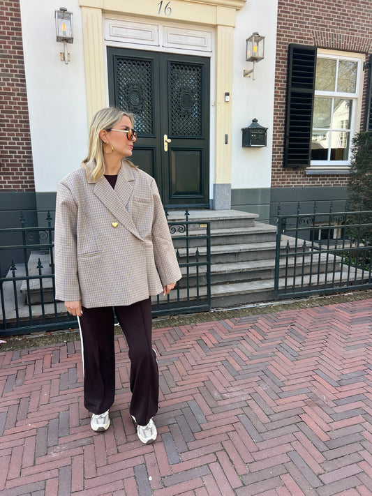 Beiger karierter Blazer mit feinem gelben Streifen von Jasmijn Dutch Atelier, getragen von einem Model in urbaner Umgebung in den Niederlanden.