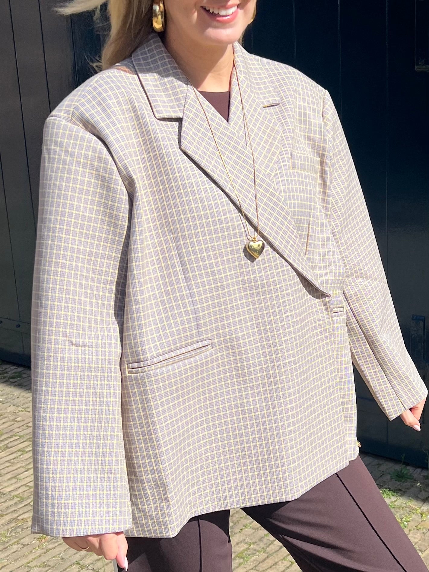 Detailaufnahme der Vorderseite eines beigen Blazers mit gelben Linien im Karomuster, hochwertige Verarbeitung von Jasmijn Dutch Atelier.