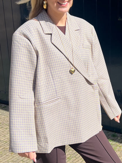 Detailaufnahme der Vorderseite eines beigen Blazers mit gelben Linien im Karomuster, hochwertige Verarbeitung von Jasmijn Dutch Atelier.