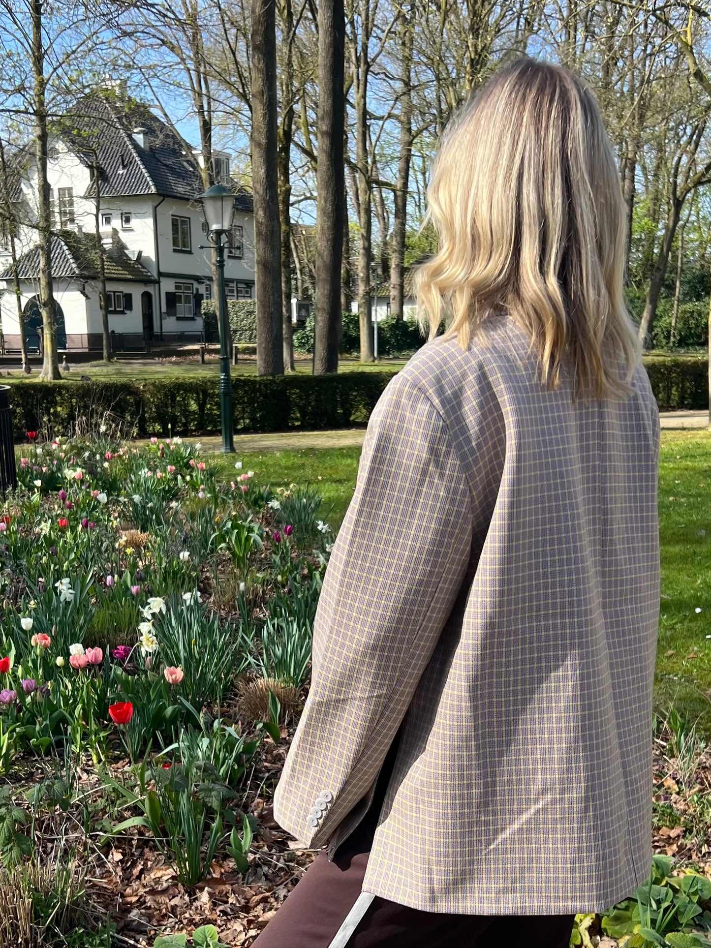 Rückansicht des beigen, karierten Blazers mit gelben Streifen, zeigt Schnitt und Passform im Detail.