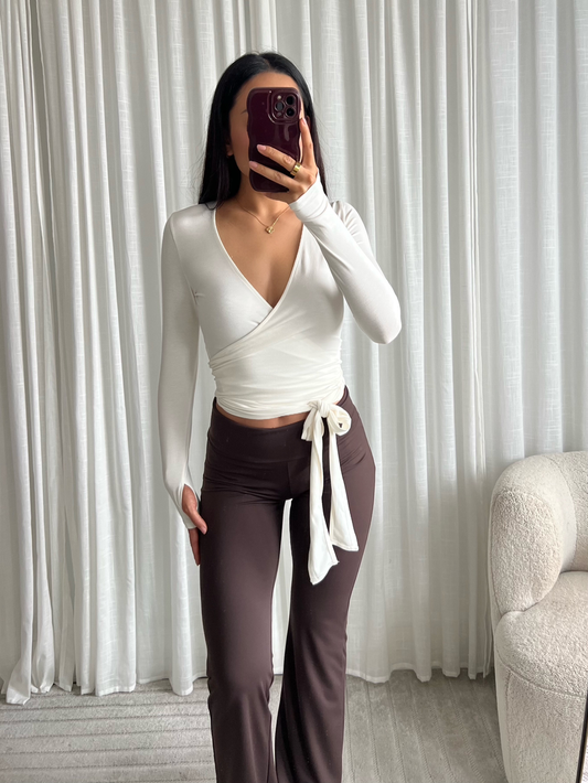 Frau trägt Lisa Wraptop Weiss mit brauner Hose Ella