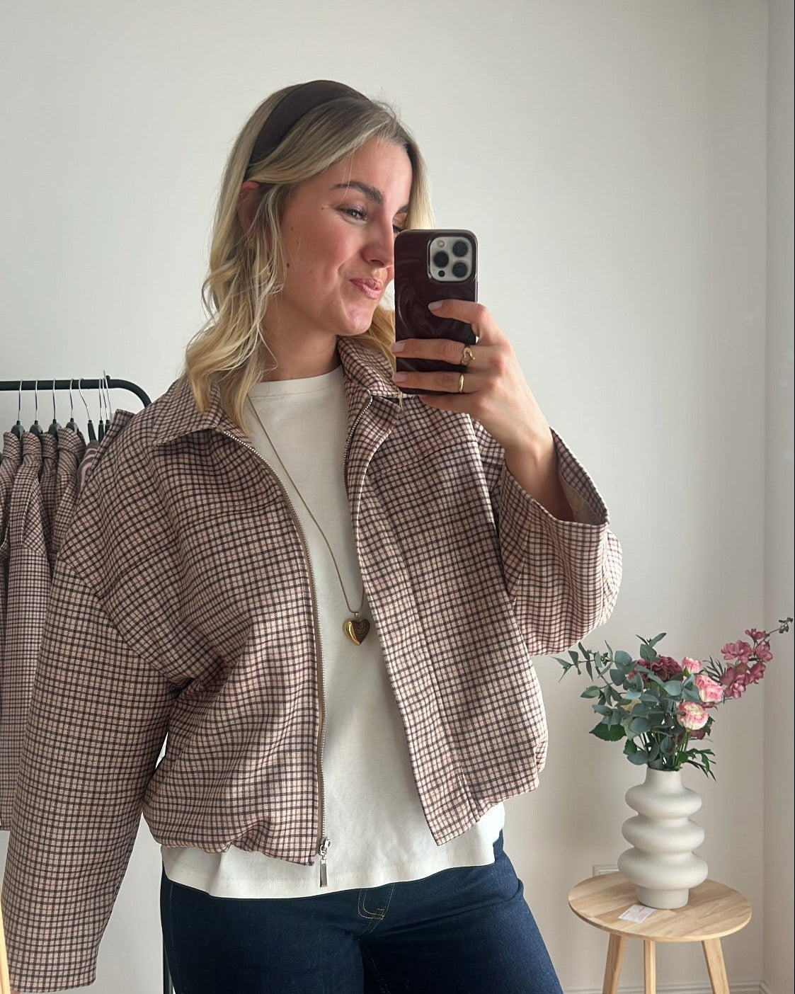 Seitenansicht eines Models mit karierter Bomberjacke kombiniert mit T-Shirt und Jeans