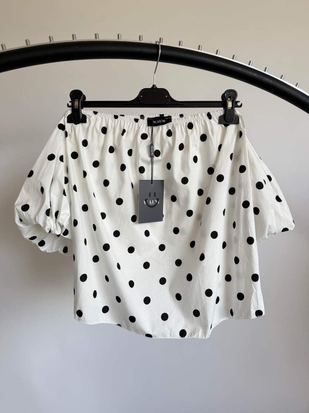 Produktfoto der weißen Polkadot Top Pien mit Puffärmeln und schwarzem Punkte-Design vor weißem Hintergrund