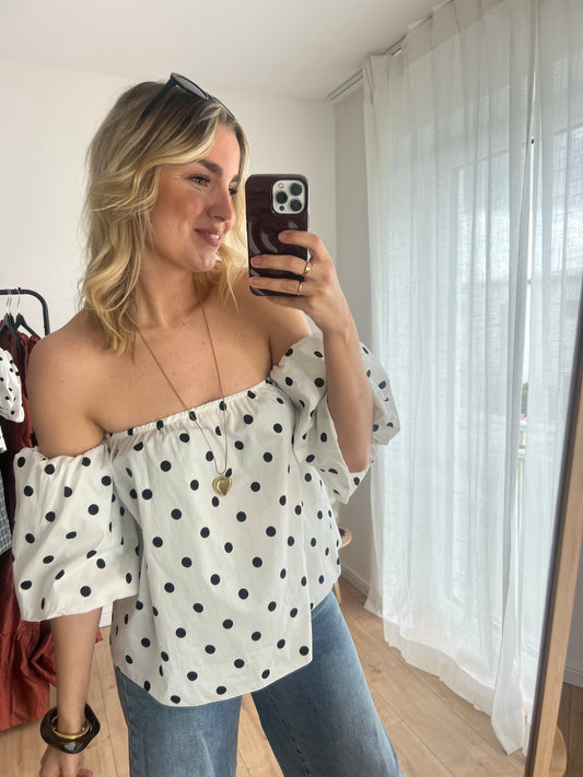 Frontale Aufnahme eines Models in der weißen Polkadot Top Pien mit schwarzen Punkten und Puffärmeln