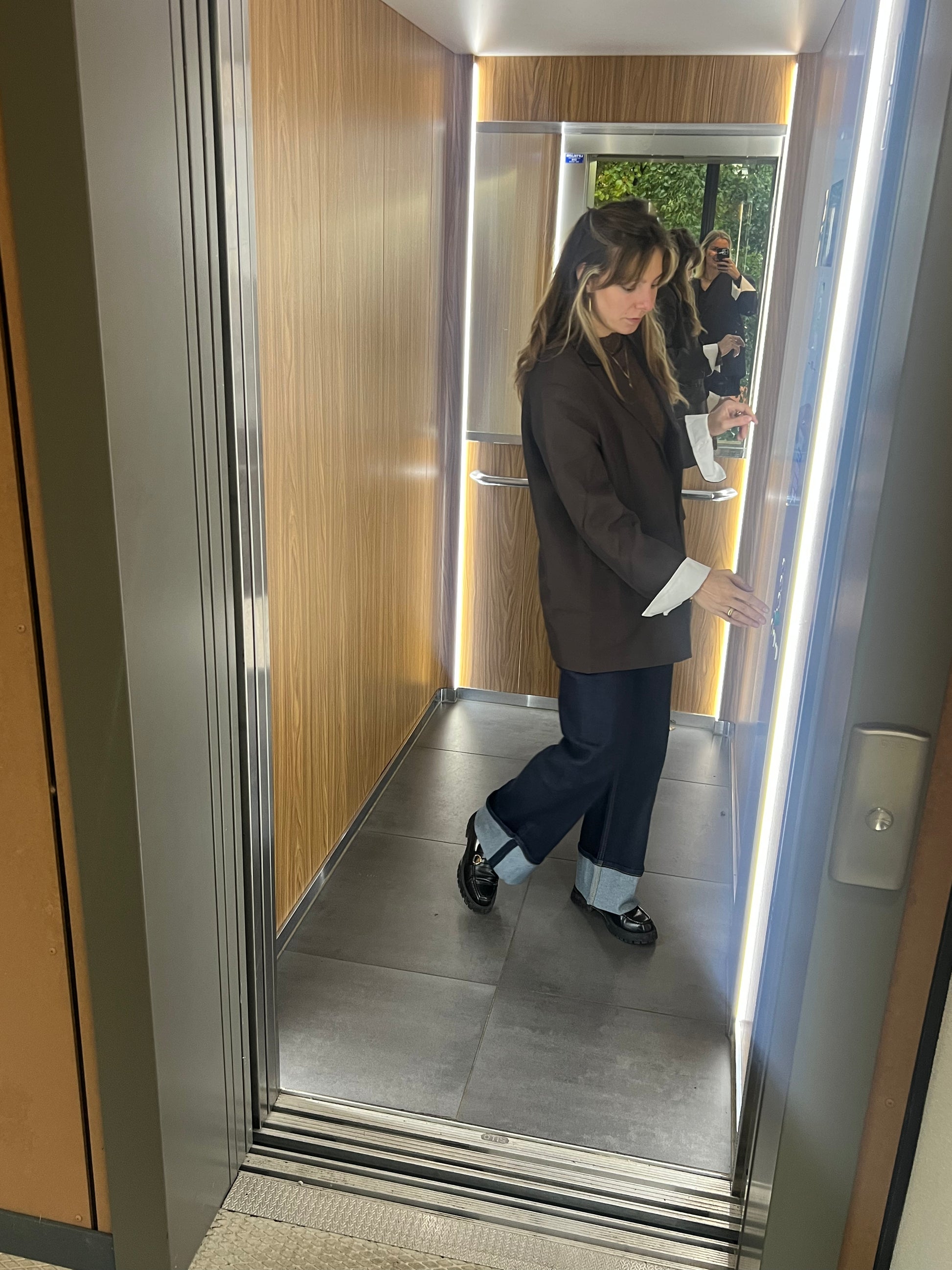 Model im Aufzug, dunkelblauen Jeans mit umgeschlagenem Bein