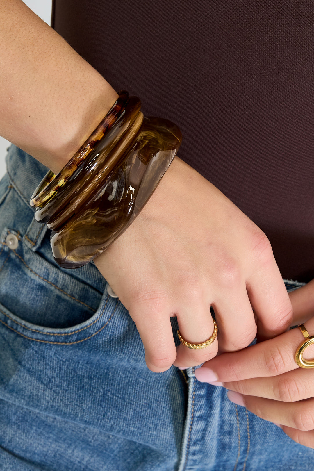 Model trägt den Bangle Claire Armreif in Braun von Dutch Atelier am Handgelenk