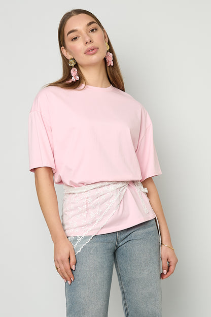 Das Model trägt das weiße Dreieckstuch „Jessy” von Dutch Atelier über einem T-Shirt um die Hüften